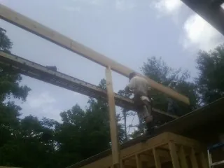 Carpenter setting a ridge beam over a new addition frame — Ice Dam Removal by Roofing Brothers in New Fairfield