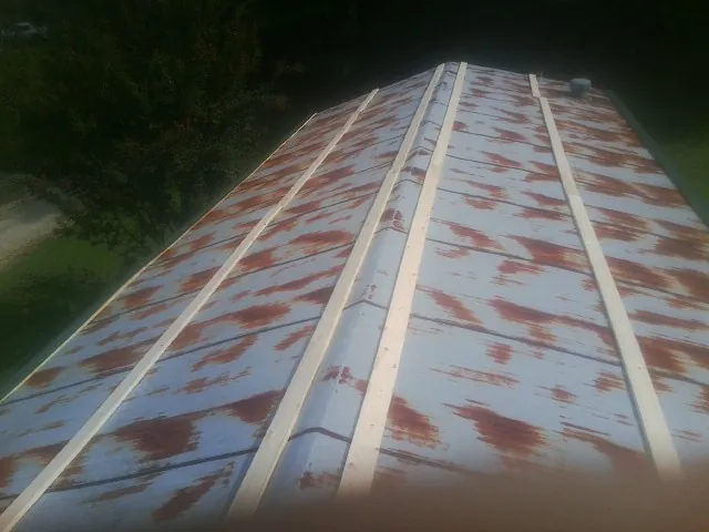 Rusted metal roof panels with new wood purlins before replacement — Storm Damage Roof Repair in New Fairfield by Roofing Brothers
