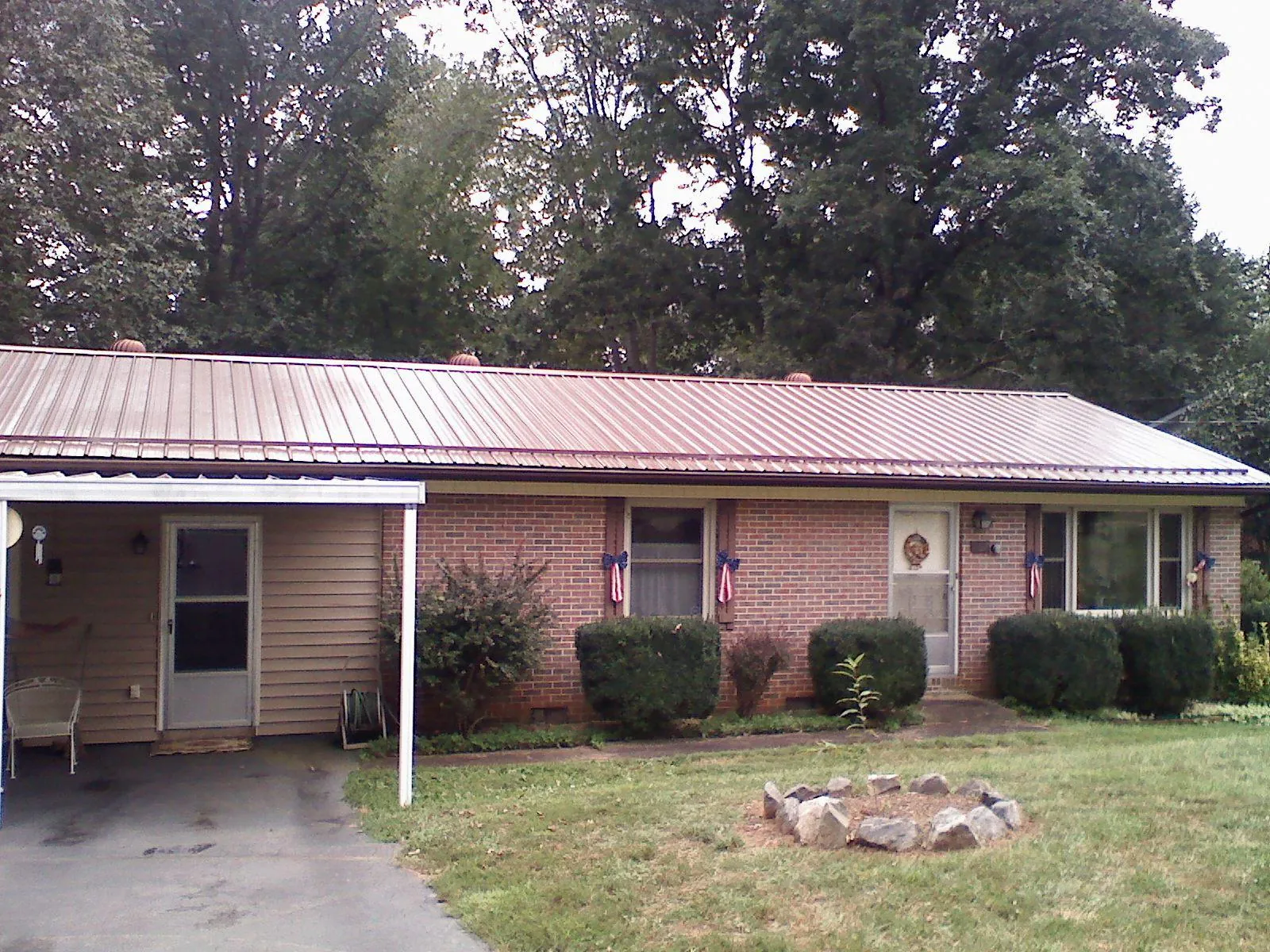 Bronze metal roof and carport on a brick ranch home — Roof Repair work by our crew in New Fairfield